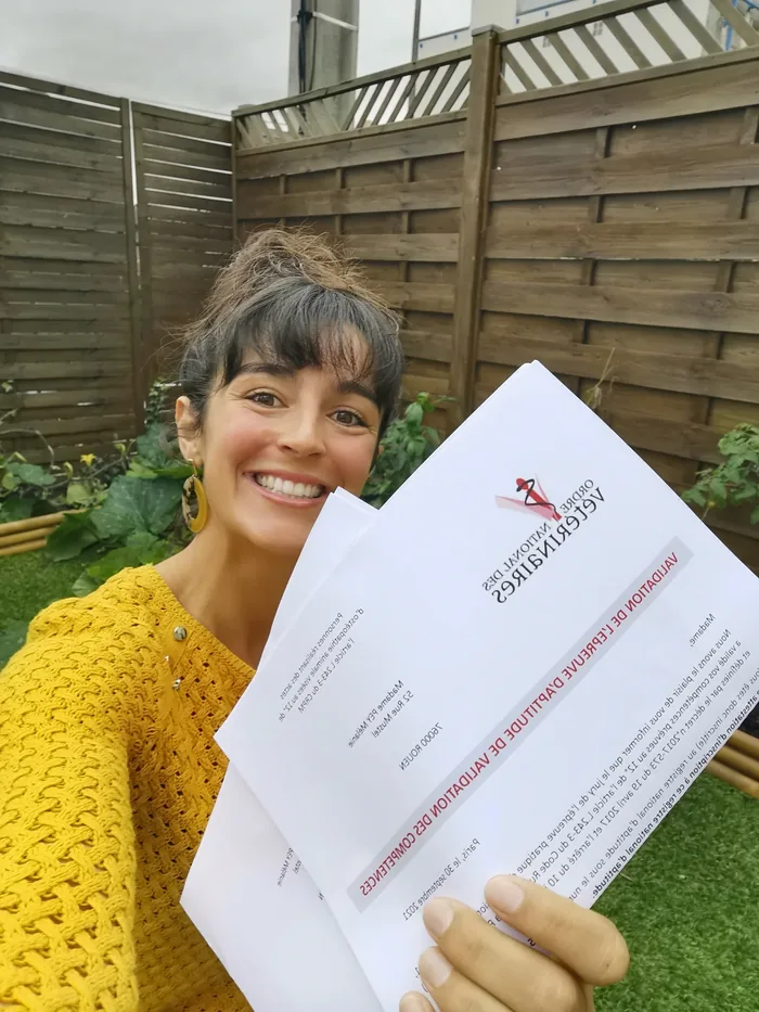 Mélanie Pey, ostéopathe animalier, présentant son certificat de formation en ostéopathie animale